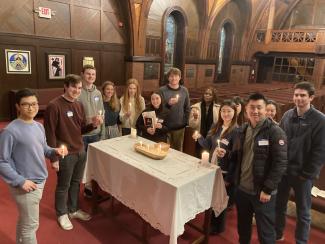 Tufts students gathering with candles in the chapel